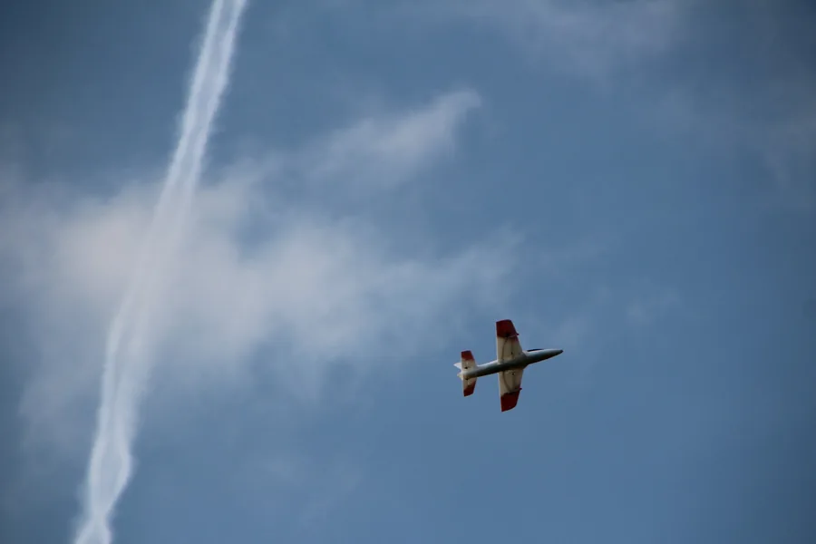 Aero-33X von unten im Kurvenflug, daneben ein Kondensstreifen